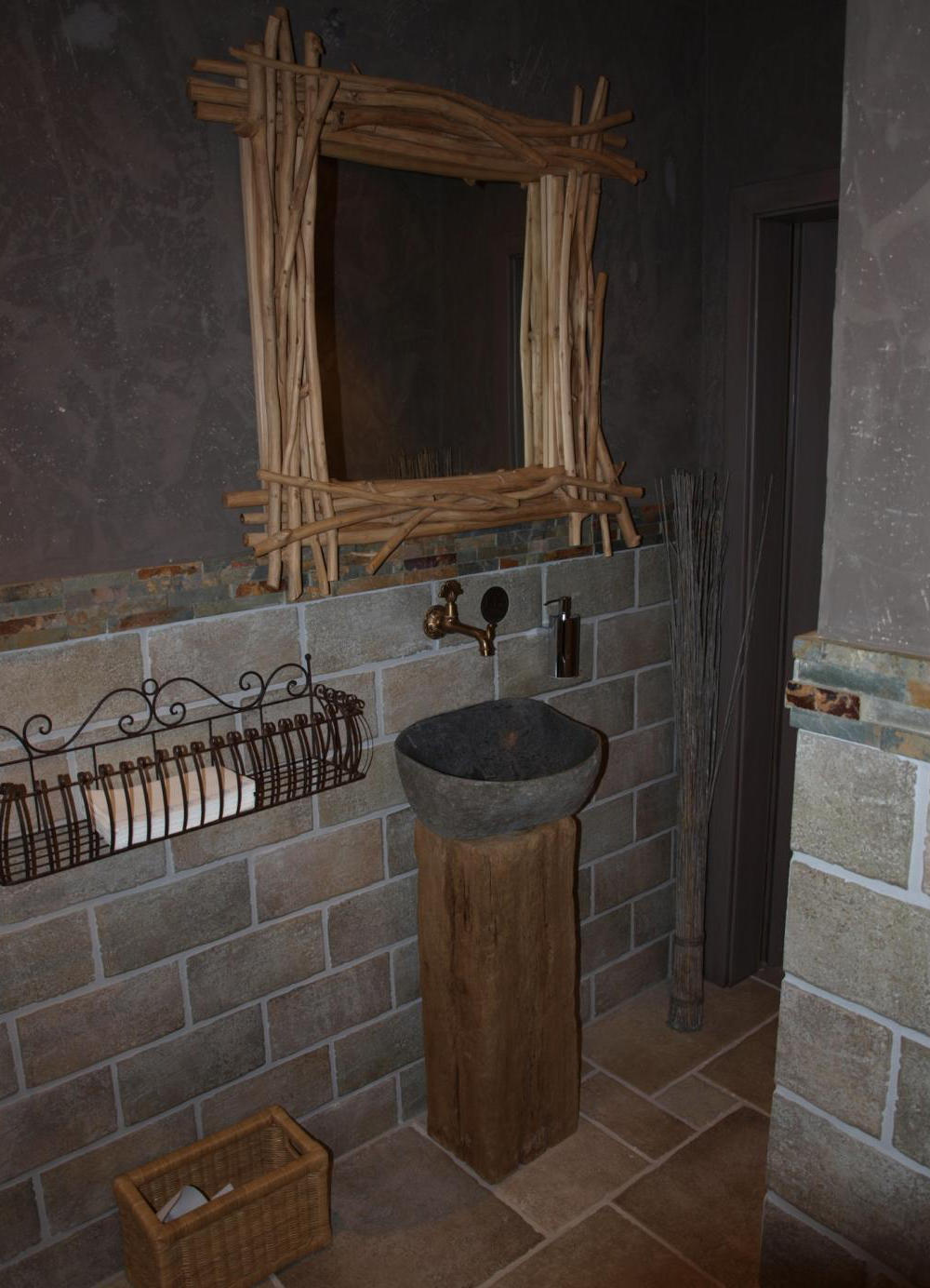 Rustikales Gästebad mit Treibholz-Spiegel, Stein-Waschbecken und handgefertigten Zementfliesen